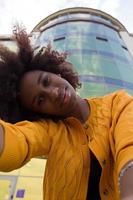 uma mulher afro-americana feliz e jovem tira uma selfie, close-up foto