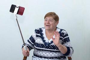 uma mulher idosa escreve um vídeo para um blog foto
