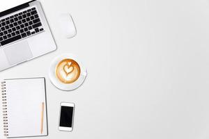 vista superior laptop ou notebook, telefone celular e xícara de café latte art na mesa de madeira. modelo de negócios simulado para adicionar seu texto. foto