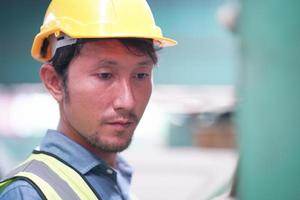 retrato de um trabalhador profissional engenheiro da indústria pesada vestindo uniforme, óculos e capacete em uma fábrica de aço. especialista industrial permanente em instalações de construção metálica. foto