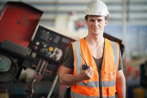 retrato de um trabalhador profissional engenheiro da indústria pesada vestindo uniforme, óculos e capacete em uma fábrica de aço. especialista industrial permanente em instalações de construção metálica. foto