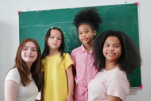 meninas felizes contra a lousa com volta às aulas foto