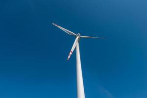 lâminas rotativas de uma hélice de moinho de vento no fundo do céu azul. geração de energia eólica. pura energia verde. foto