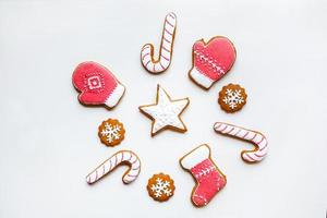 biscoitos de gengibre festivos artesanais em forma de estrelas, flocos de neve, pessoas, meias, funcionários, luvas, árvores de natal, corações para férias de natal e ano novo em fundo de papel branco foto