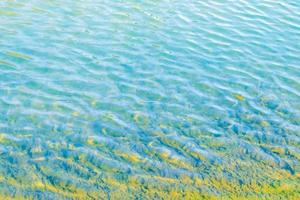 beira-mar com água turquesa de fundo transparente do oceano. textura aqua de ondulação azul clara foto