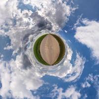 pequena transformação do planeta do panorama esférico 360 graus. vista aérea abstrata esférica na estrada com céu azul e lindas nuvens impressionantes. curvatura do espaço. foto