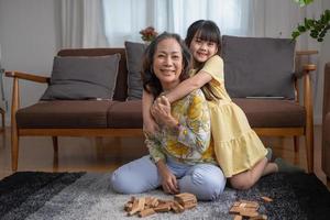 avó e neta jogam. quebra-cabeça de bloco para desenvolver habilidades para neta e como atividade de férias foto