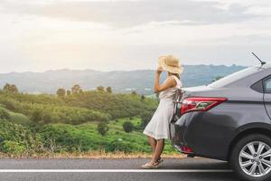 jovem viajante olhando bela paisagem com carro em roadtrip, férias de verão foto