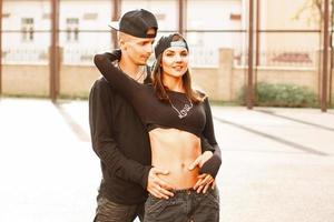 jovem casal em um elegante vestido preto com um boné de beisebol. foto