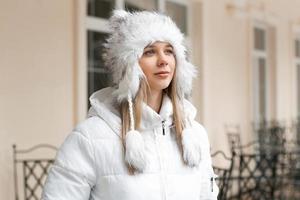 mulher bonita na jaqueta de inverno olhando perto do prédio foto