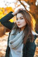 linda garota com um suéter de malha e jaqueta no parque outono foto