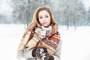 menina bonita com um cachecol estilo vintage e luvas em dia de inverno foto