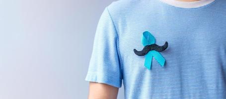 novembro mês de conscientização do câncer de próstata, fita azul com bigode para apoiar pessoas vivas e doentes. cuidados de saúde, homens internacionais, pai e conceito de dia mundial do câncer foto