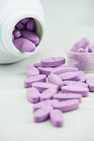 pílulas violetas um frasco de comprimidos em cima da mesa. foto