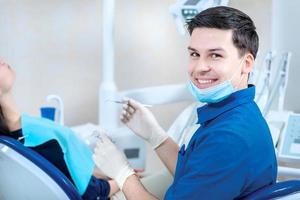 médico dentista de sucesso. dentista sorridente verifica os dentes de t foto