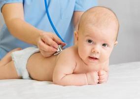 médico com estetoscópio ouve bebê