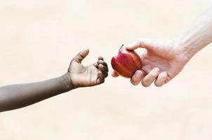 símbolo de saúde: dar maçãs para ajudar crianças de etnia africana negra foto