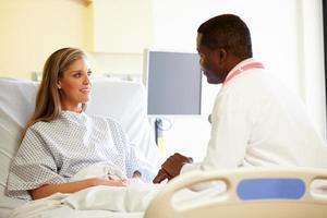 médico falando com paciente do sexo feminino no quarto do hospital foto