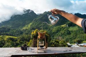 gotejamento de café na varanda e vista para a montanha foto