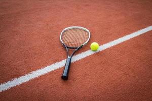 raquete de tênis e bola na quadra