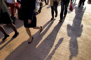 empresária asiática andando na rua com longas sombras foto