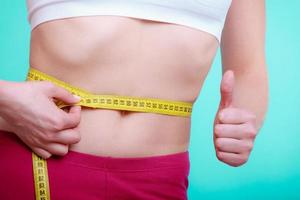 dieta. mulher de fitness cabe garota com fita métrica, medindo a cintura
