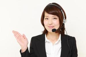mulher de negócios japonesa do call center, apresentando e mostrando algo