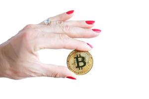 mão de mulheres de bitcoin dourado de dinheiro virtual com dedos de unhas vermelhas isolados no fundo branco foto