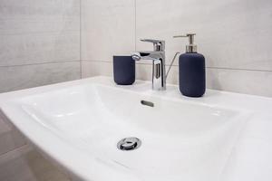dispensadores de sabonete e xampu na pia da torneira de água com torneira no banheiro caro loft