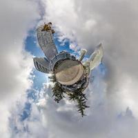 pequeno planeta no céu azul com nuvens no centro da cidade perto de modernos arranha-céus ou edifícios de escritórios. transformação do panorama esférico 360 em vista aérea abstrata. foto