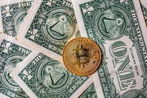 dinheiro virtual bitcoin dourado em um fundo de nota de dólar. conceito de nova ordem mundial de criptomoeda. troque bitcoin em dinheiro por um dólar. foto