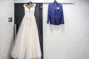 vestido de terno da noiva e do noivo pendurar em um cabide foto