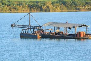 as embarcações de sucção de areia estão transportando areia de tubos de aço em rios profundos para a construção de indústrias como casas, prédios, estradas e muitas outras onde a areia é usada como mistura. foto