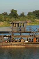 as embarcações de sucção de areia estão transportando areia de tubos de aço em rios profundos para a construção de indústrias como casas, prédios, estradas e muitas outras onde a areia é usada como mistura. foto