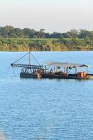 as embarcações de sucção de areia estão transportando areia de tubos de aço em rios profundos para a construção de indústrias como casas, prédios, estradas e muitas outras onde a areia é usada como mistura. foto