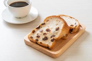 pão de passas com xícara de café foto