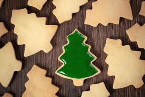vista superior do biscoito de árvore de natal decorado no fundo da mesa de madeira com espaço de cópia. foto