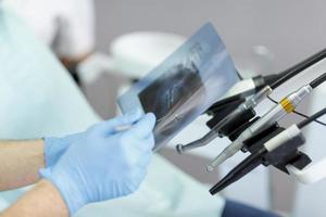 mão de dentista segurando o equipamento dental foto