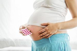 mulher grávida com pílulas foto