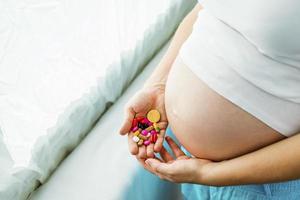 mulher grávida com pílulas foto