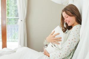 mulher sentada na cama com seu filho recém-nascido