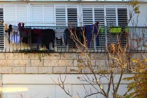 linho lavado seca na rua do lado de fora da janela da casa. foto