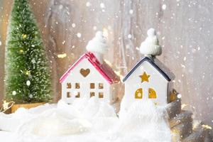 casa aconchegante está embrulhada em um chapéu e cachecol em uma tempestade de neve - decoração de peitoril da janela para o natal, ano novo. inverno, neve - isolamento doméstico, proteção contra o frio e o mau tempo, sistema de aquecimento. Humor festivo foto