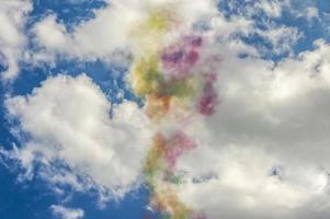 fumaça colorida no céu azul com nuvens foto