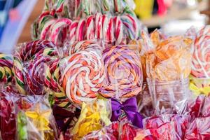 closeup de pirulitos coloridos em varas no mercado de rua foto
