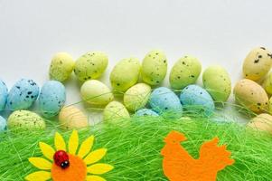 grama artificial com ovos coloridos, girassol e fundo de galo foto