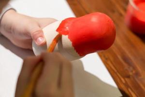 menina pinta boneca russa chamada matrioshka com tinta vermelha foto