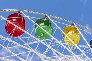 roda gigante colorida contra o céu azul com nuvens foto