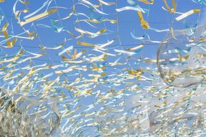 cordas brancas, azuis e douradas contra o céu azul, decoração do festival de rua foto