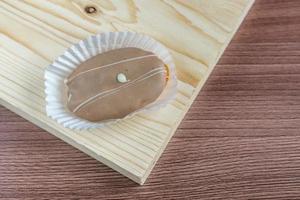 closeup de eclair de chocolate na mesa de madeira foto